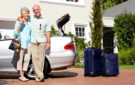 Florida seasonal residents next to a convertible with packed suitcases